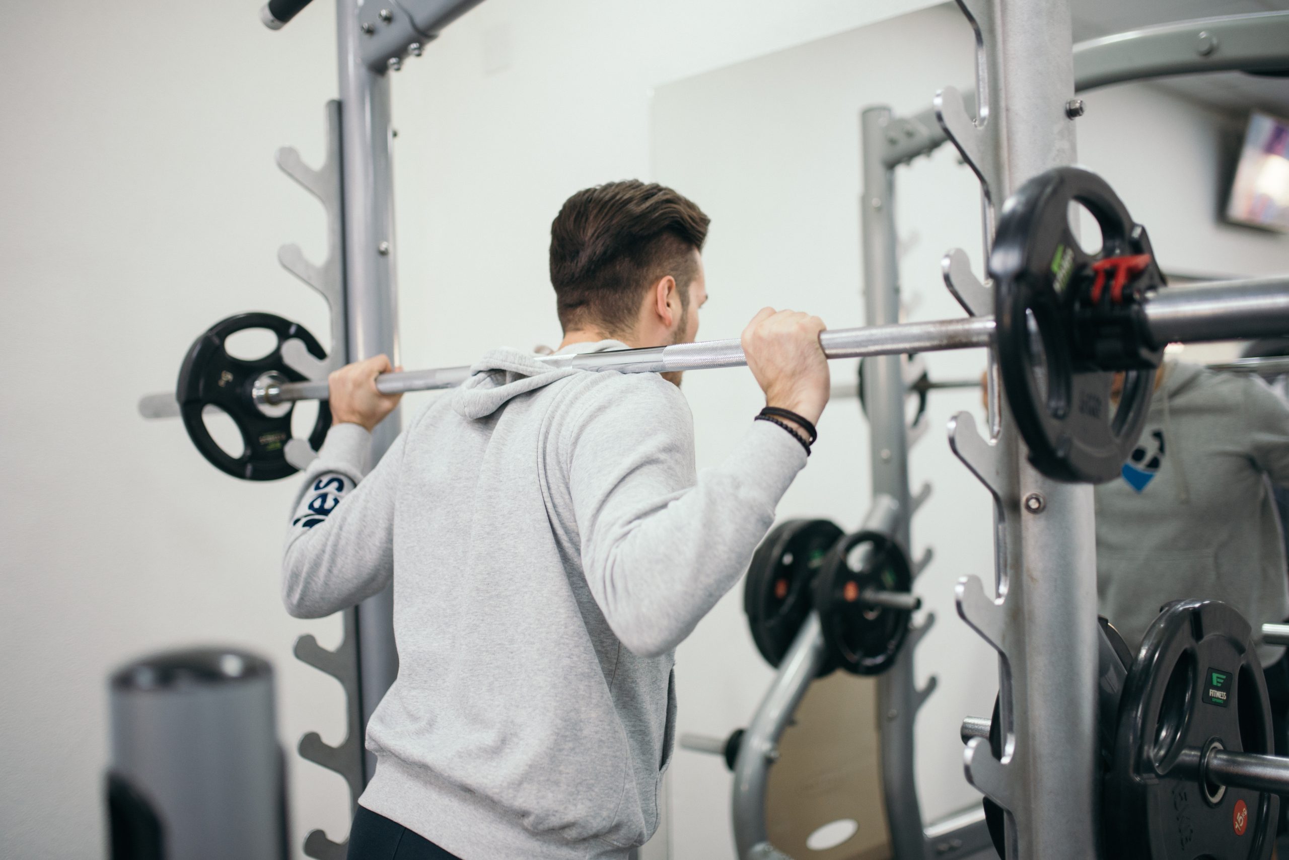 Young attractive man athlete doing exercise with the barbell in the gym.jpg